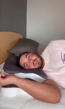 A man lying on his side on the Cradleform pillow