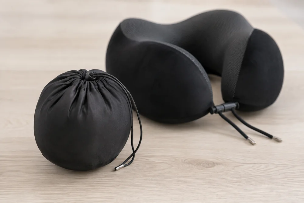 The travel pillow compressed into its round carry pouch